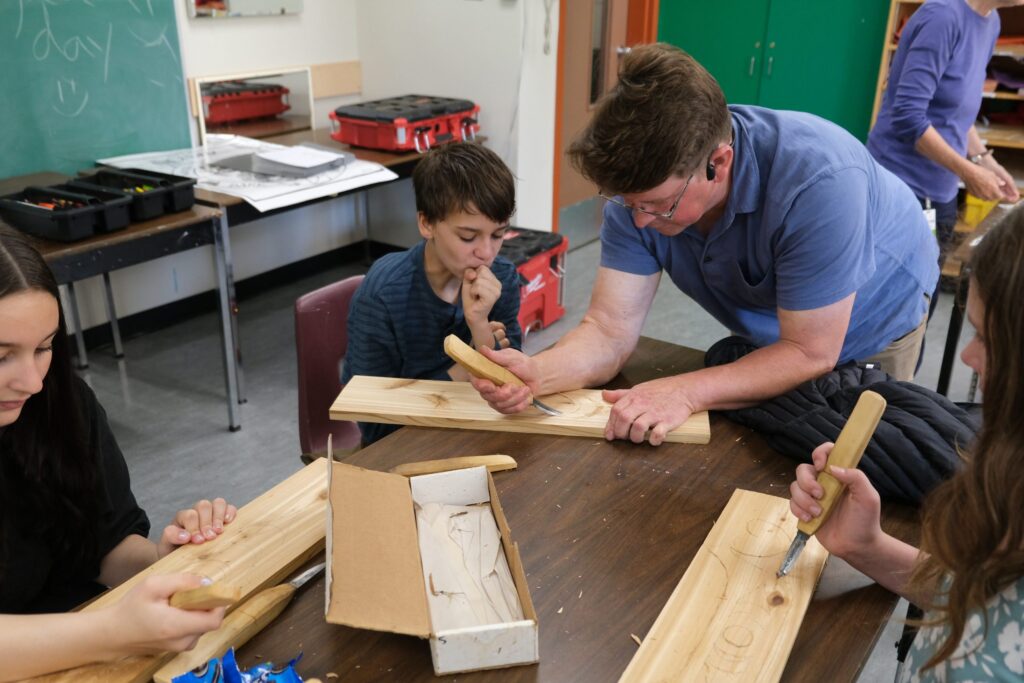 Beau Wagner instructs intermediate students on how to carve.